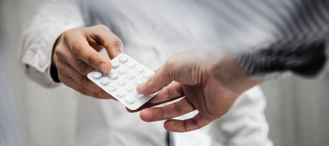 Médico dando unas pastillas